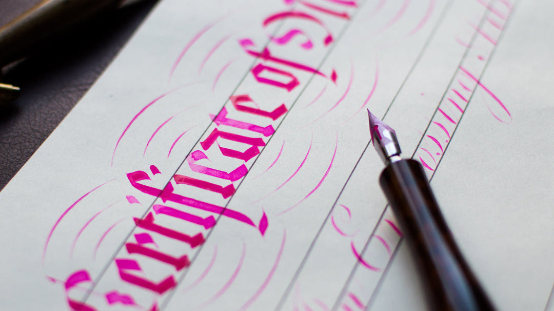 Pink ink calligraphy that reads "certificate" with a dip pen posed on top