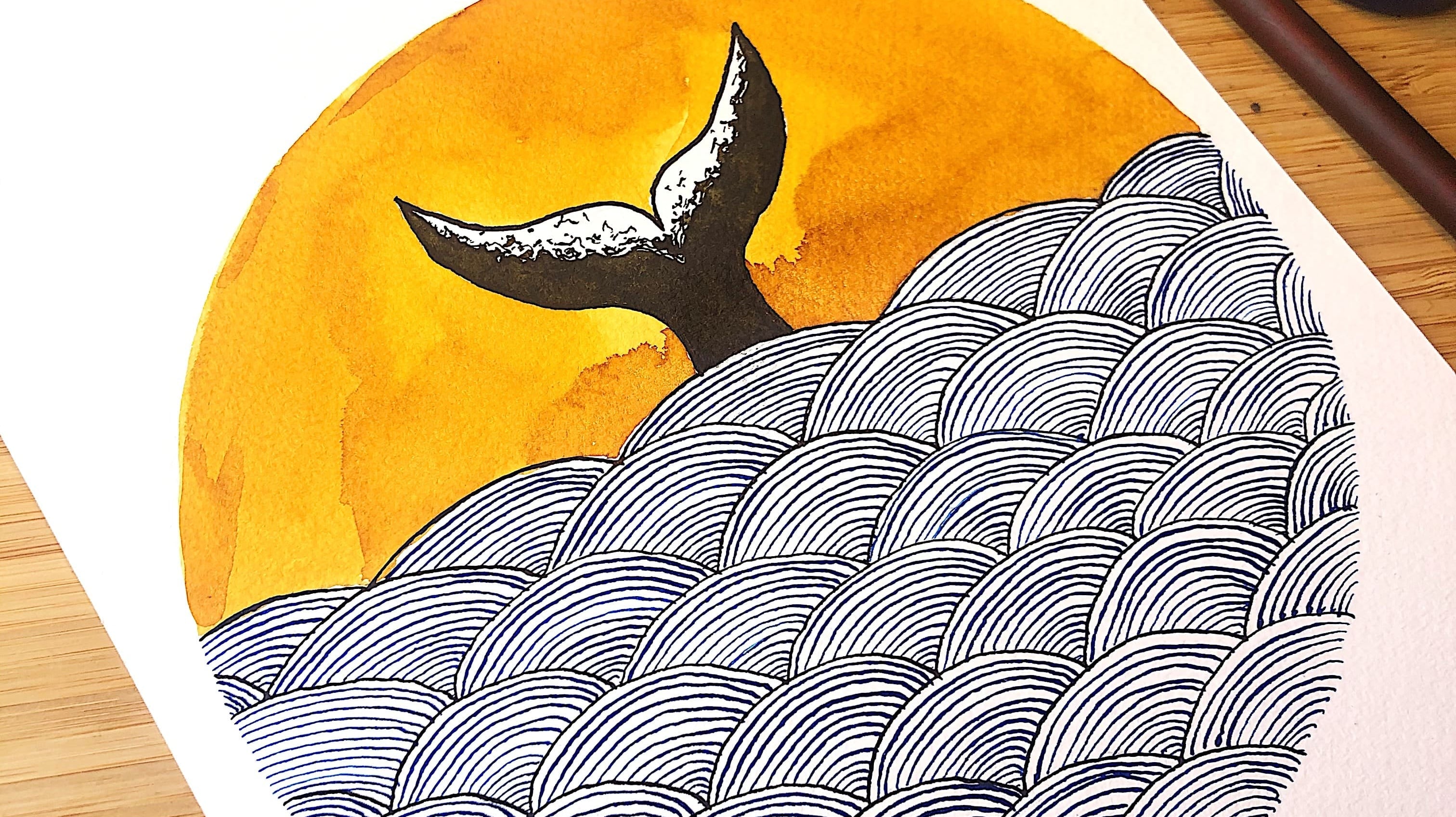 A circular artwork of a whale tail in the ocean drawn with a dip nib and inks