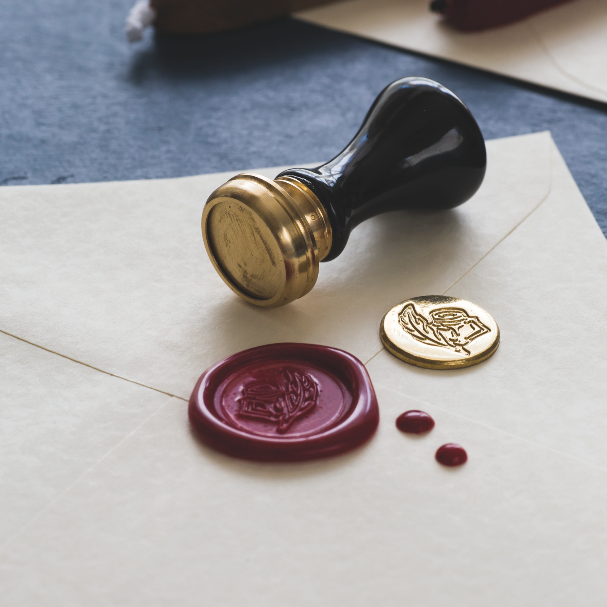 Wax seal stamp with a purple wax seal on an envelope