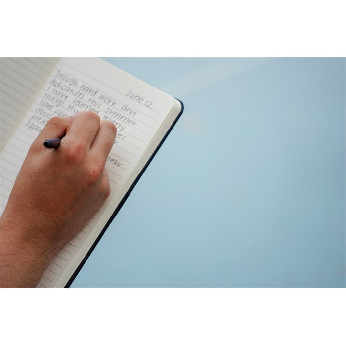 Hand writing in a notebook on a light blue background
